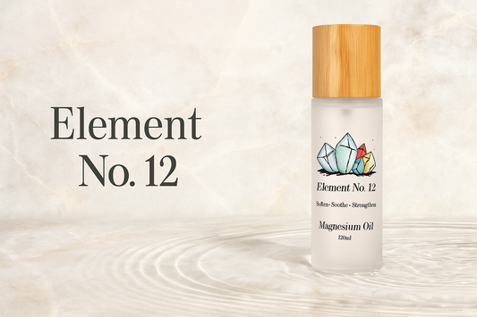 frosted glass bottle of magnesium oil with natural bamboo lid and crystal design labeled Element No. 12 on beige background